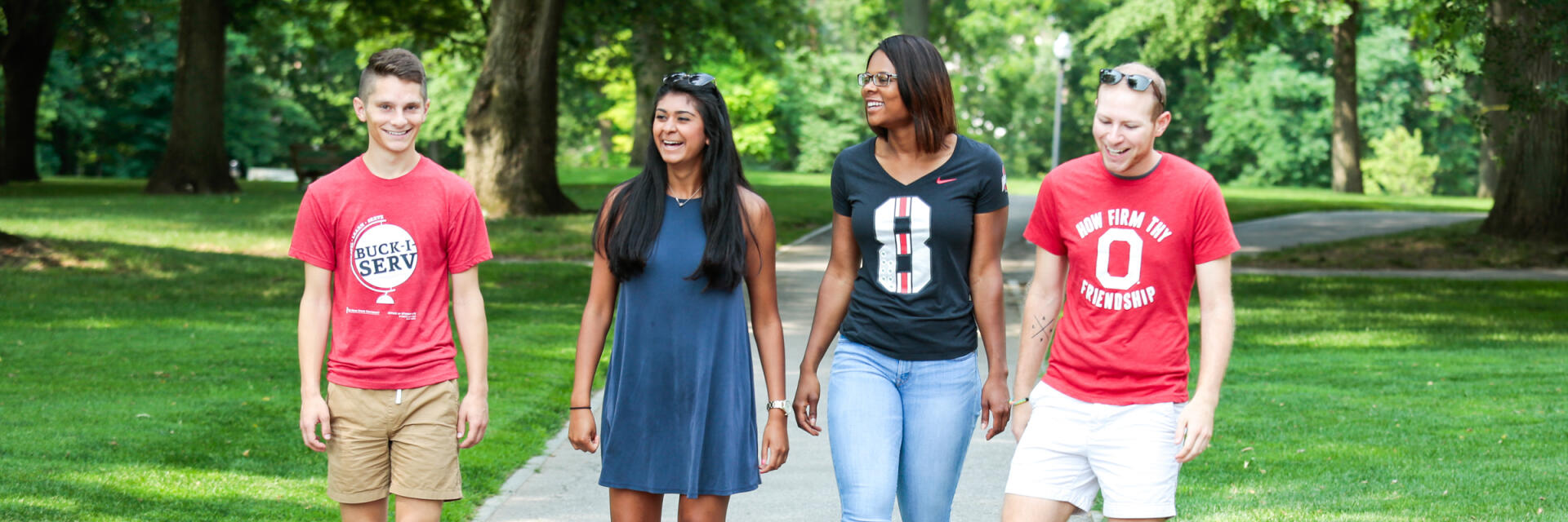 Group of four students walking on campus.