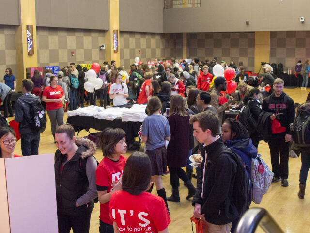 Photo of students gathered in a big room and participating at an ROUK? Day event