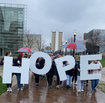 Attendees of OOTDW walking with the letter signs, spelling out HOPE