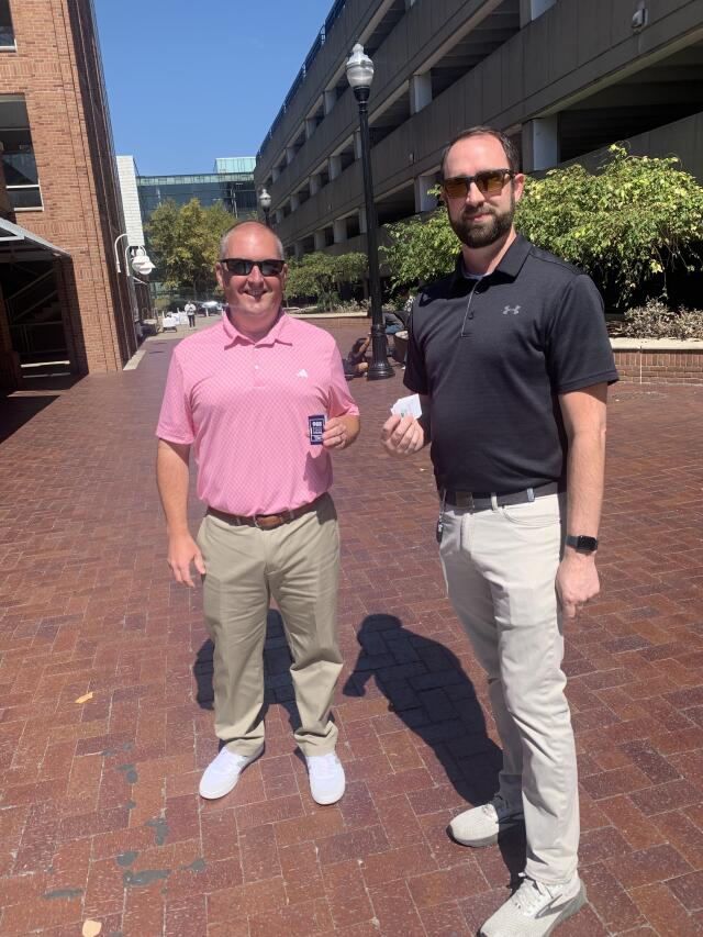 Two men holding 988 crisis stickers