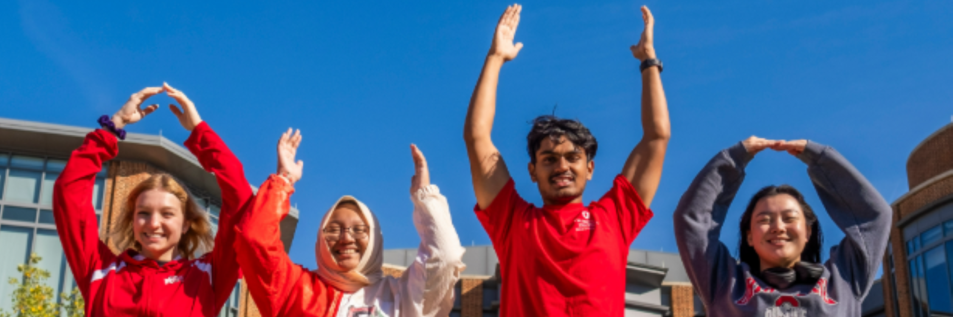Group of four students spelling out OHIO with their arms.